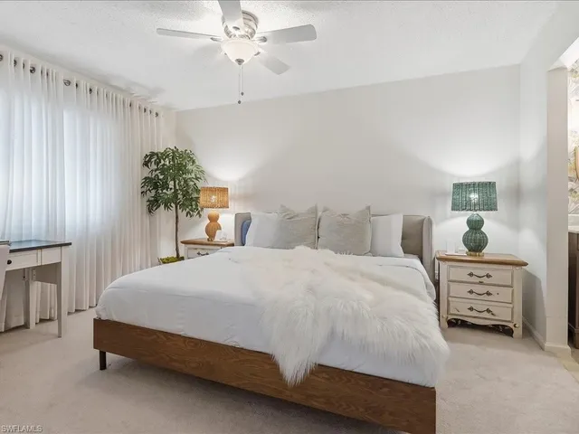a bedroom with a bed and a potted plant on dresser