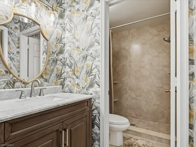 a bathroom with a granite countertop sink toilet and shower