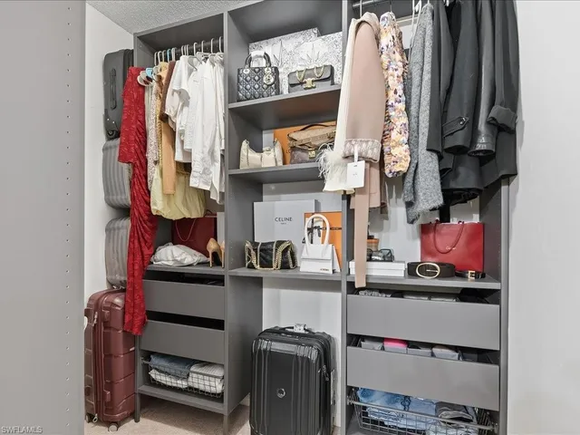 a view of walk in closet with clothes and shoes