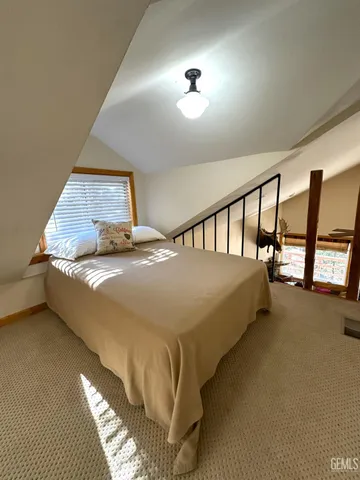 a bed sitting in a room next to a lamp