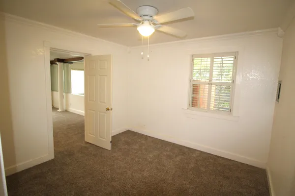 an empty room with a window and a fan