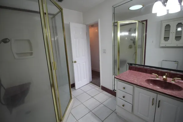 a spacious bathroom with a mirror sink and shower