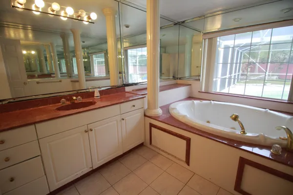 a bathroom with a granite countertop sink mirror and bathtub