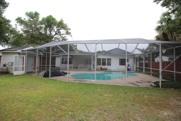 a view of pool with yard in front of it