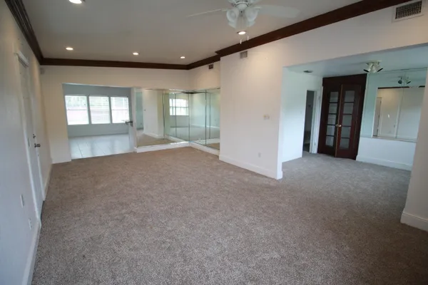 an empty room with windows and cabinet