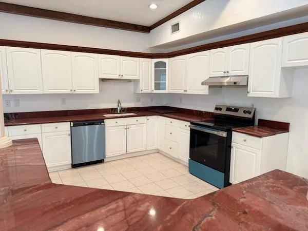 a kitchen with stainless steel appliances granite countertop a sink stove and cabinets