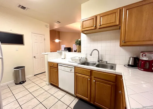 a kitchen with stainless steel appliances granite countertop a sink and a refrigerator
