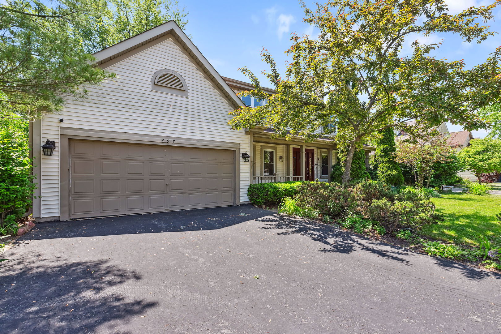 497 Farm Bridge Road Lake Zurich, IL 60047 - Photo 2 of 27 a front view of a house with a yard and garage