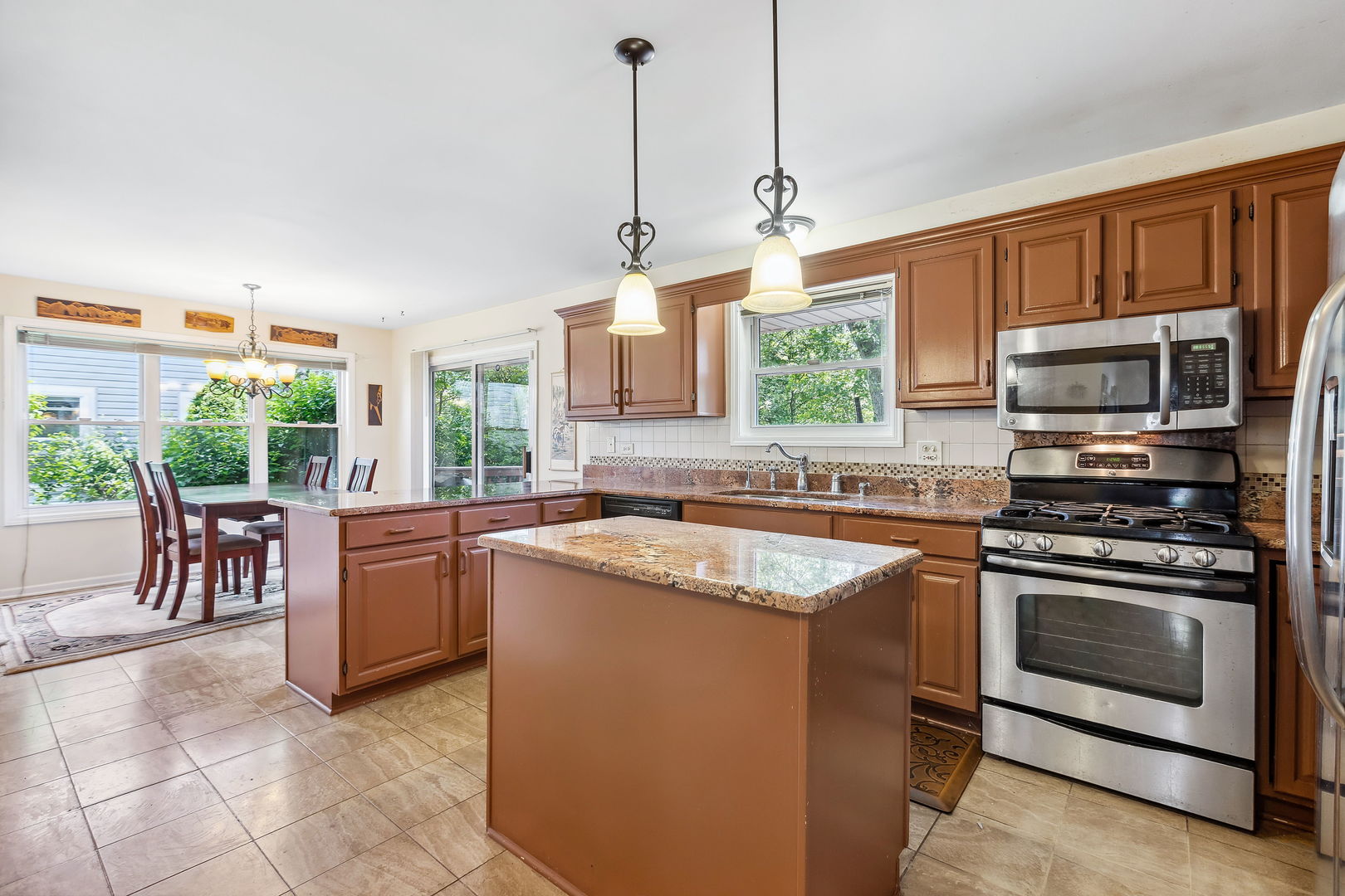 497 Farm Bridge Road Lake Zurich, IL 60047 - Photo 7 of 27 a kitchen with stainless steel appliances granite countertop a stove a sink and a microwave