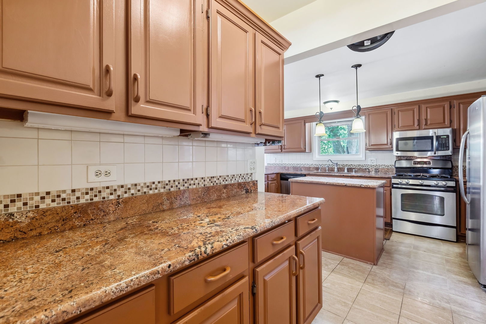 497 Farm Bridge Road Lake Zurich, IL 60047 - Photo 8 of 27 a kitchen with stainless steel appliances granite countertop a sink a stove and cabinets