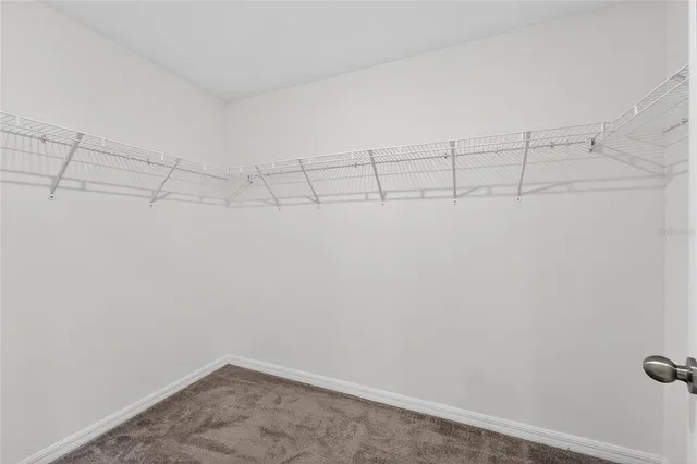 an empty room with ceiling fan and window