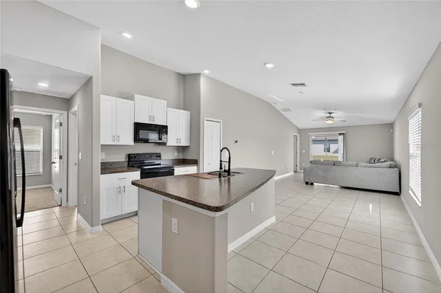 a kitchen with stainless steel appliances granite countertop a stove a sink and a microwave