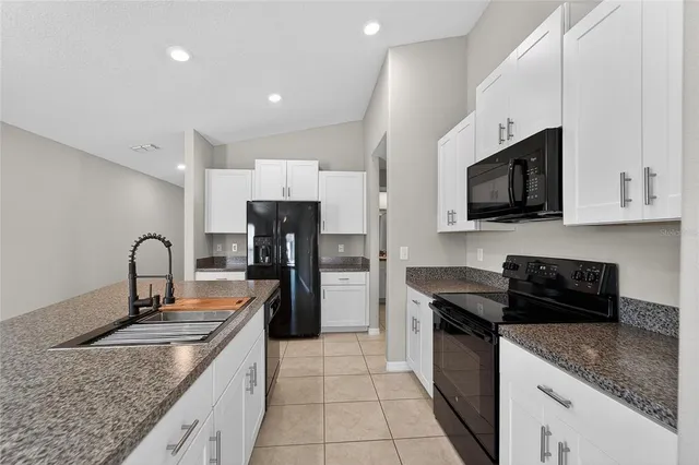 a kitchen with stainless steel appliances granite countertop a refrigerator and a sink