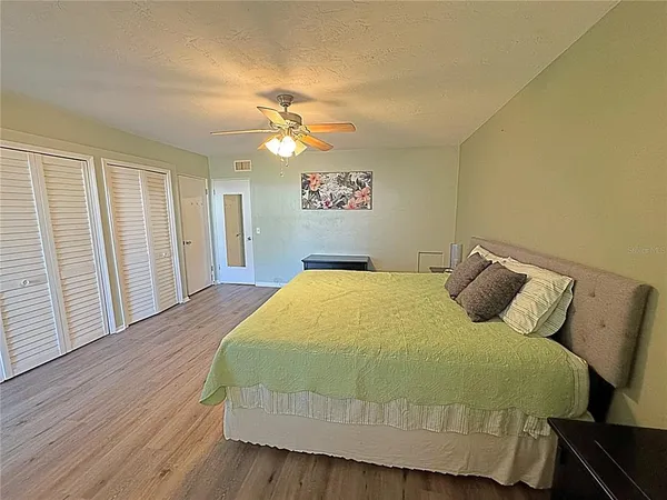 a bedroom with a bed and wooden floor