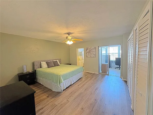 a spacious bedroom with a bed and wooden floor