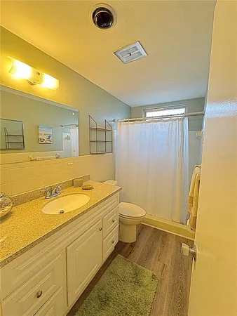 a spacious bathroom with a granite countertop sink and a mirror