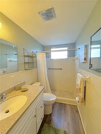a bathroom with a granite countertop sink toilet and shower
