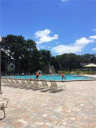a view of a swimming pool with a yard and sitting area