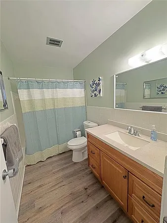 a spacious bathroom with a granite countertop sink a toilet and a shower