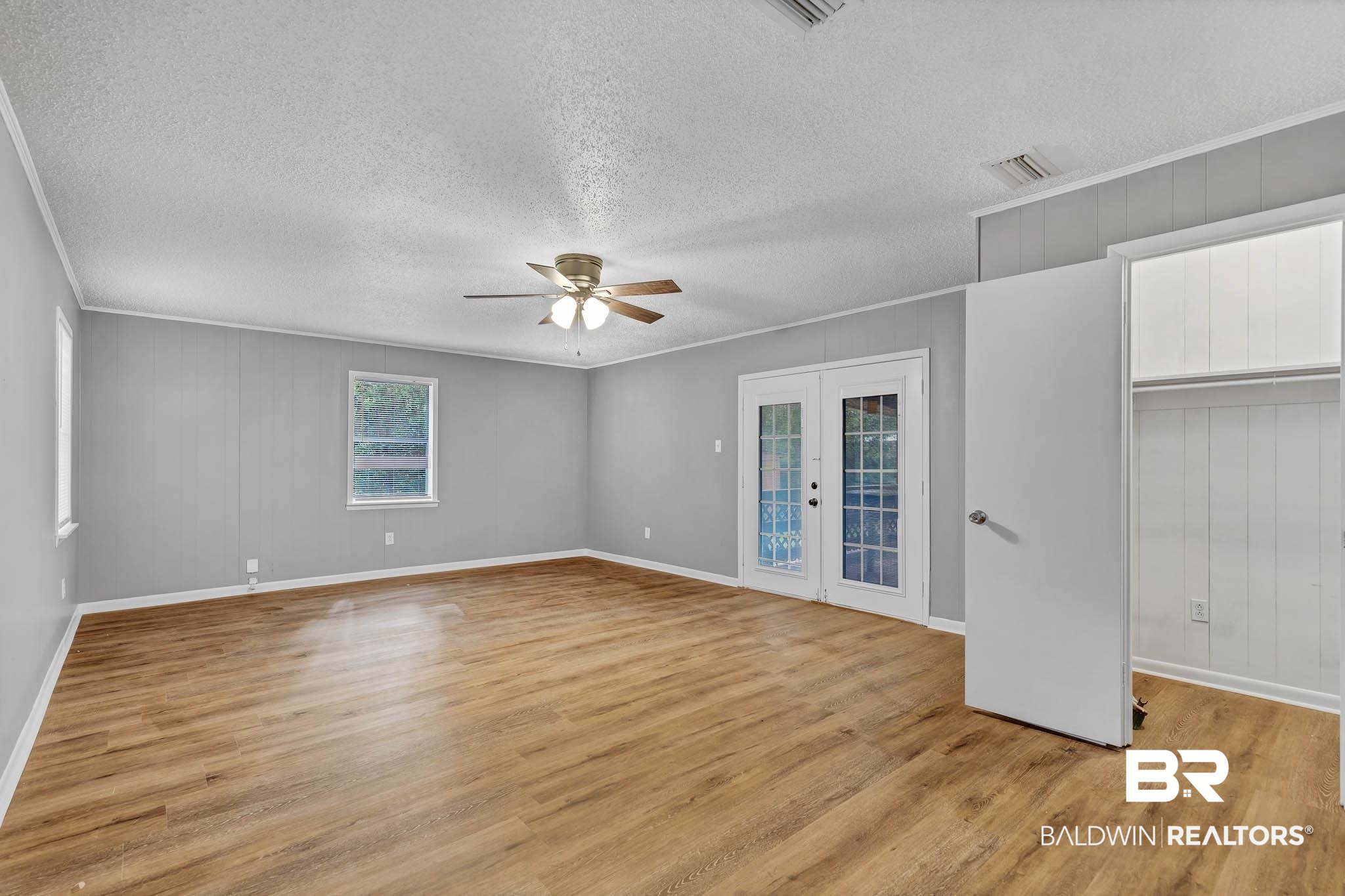 3304 Armond Drive Mobile, AL 36605 - Photo 25 of 62 Unfurnished bedroom with light wood-style flooring, a textured ceiling, ornamental molding, a ceiling fan, and access to outside