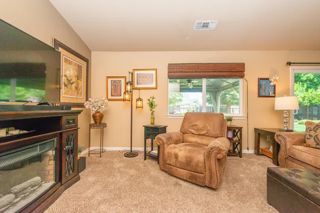 a living room with furniture kitchen view and a chandelier