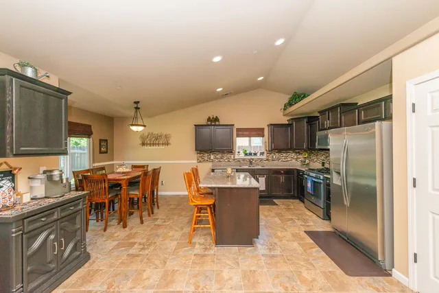 a kitchen with stainless steel appliances granite countertop a refrigerator and a stove top oven
