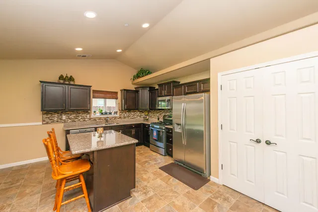 a kitchen with stainless steel appliances granite countertop a sink stove and refrigerator