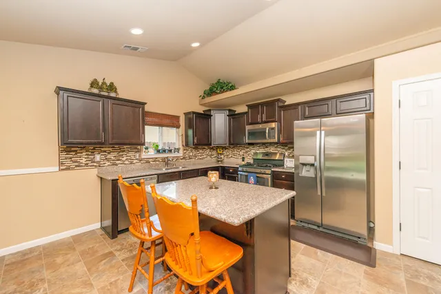 a kitchen with stainless steel appliances granite countertop a sink stove and refrigerator
