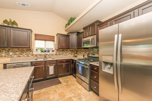 a en suite bathroom with a granite countertop sink and a large mirror