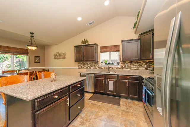 a kitchen with stainless steel appliances granite countertop a stove refrigerator and microwave