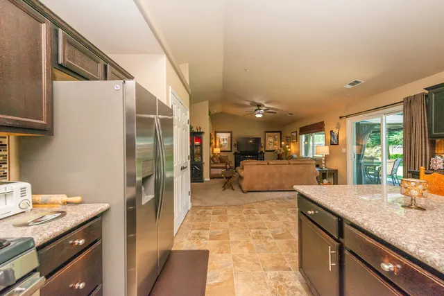a kitchen with kitchen island granite countertop a sink stove and refrigerator