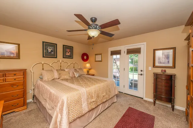 a view of patio with table and chairs under an umbrella with a small yard