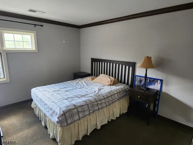 a bedroom with bed wooden floor and window