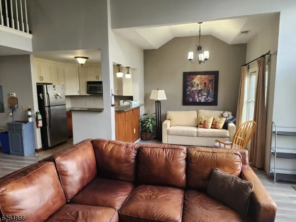 a living room with furniture kitchen and a chandelier