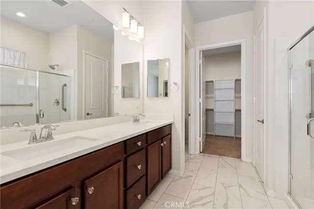 a spacious bathroom with a double vanity sink a mirror and a shower
