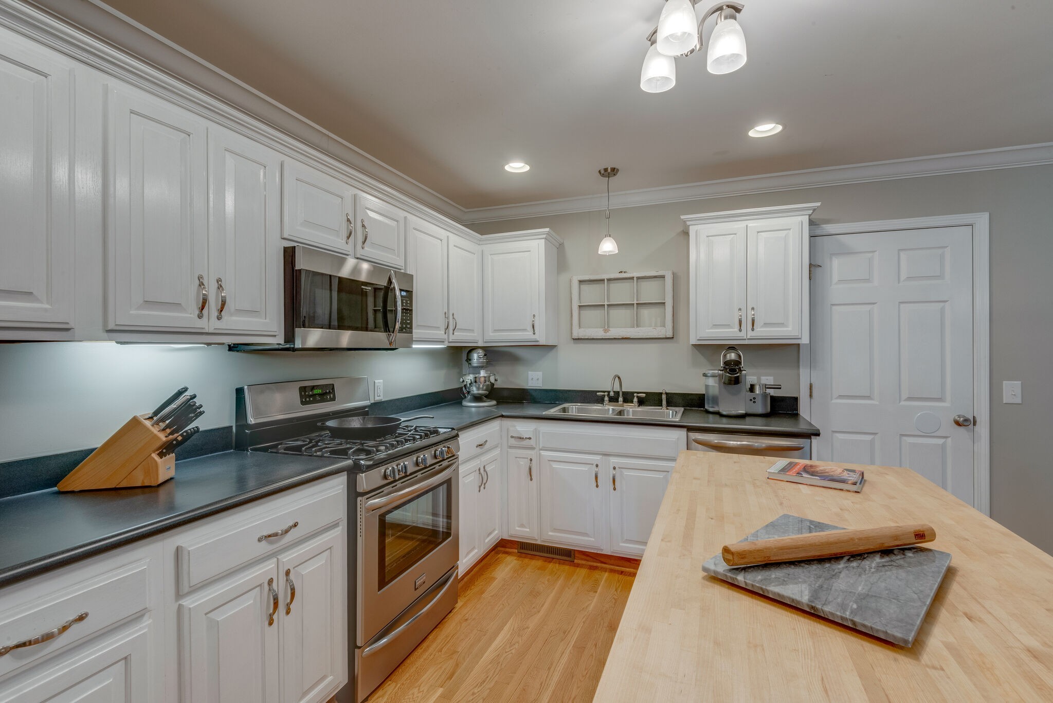 994 Hoover Road Burns, TN 37029 - Photo 15 of 28 a kitchen with stainless steel appliances granite countertop white cabinets granite counter tops and a hard wood floors