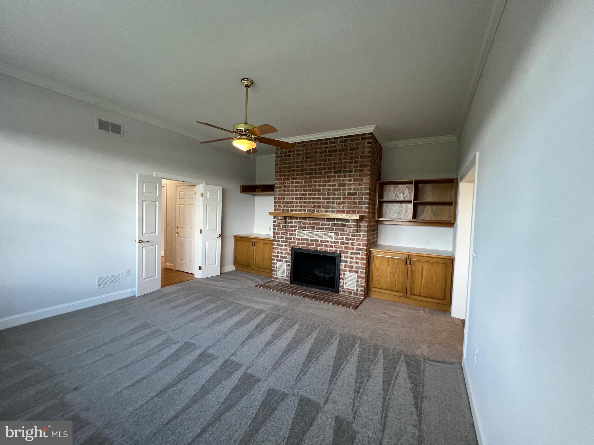 1343 Phoenix Road Sparks Glencoe, MD 21152 - Photo 18 of 57 a view of a livingroom with a fireplace a ceiling fan and brick wall