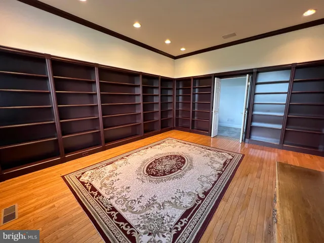 a view of a hallway with wooden floor and stairs