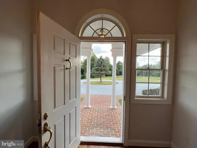 a view of empty room with wooden floor and fireplace
