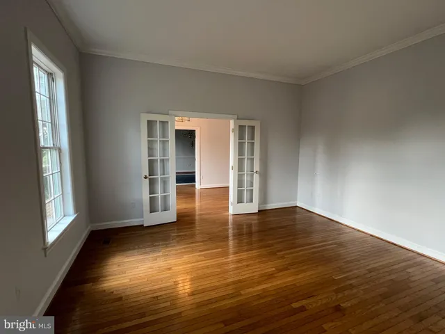 a view of a chandelier in big room with wooden floor