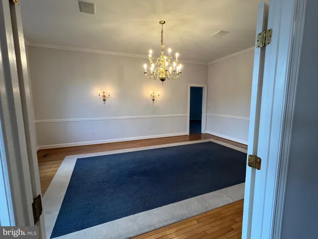 a kitchen with wooden floor white cabinets and stainless steel appliances