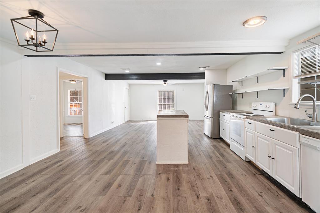 2413 Simpson Street Paris, TX 75460 - Photo 4 of 15 a large kitchen with cabinets wooden floor and stainless steel appliances