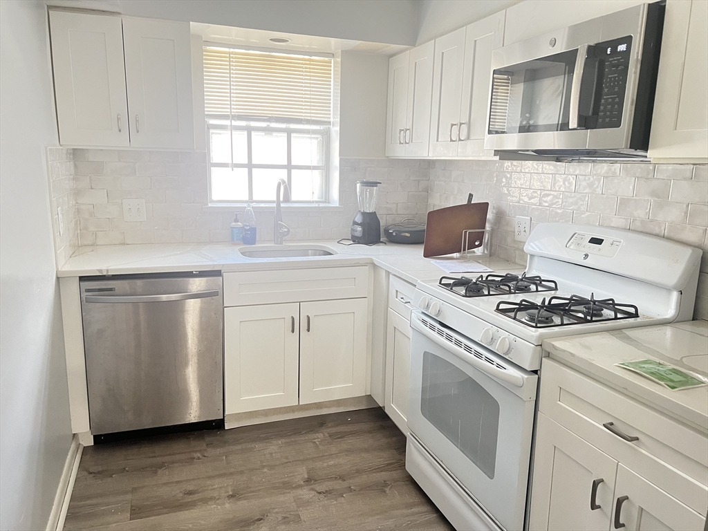 11 Lake Shore Court, Unit 2 Boston, MA 02135 - Photo 1 of 9 a kitchen with white cabinets and appliances