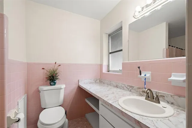 a bathroom with a granite countertop toilet sink and mirror