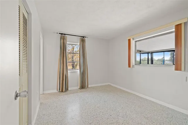 an empty room with windows and closet