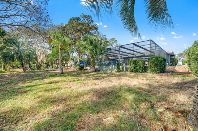 a backyard of a house with table and chairs under an umbrella