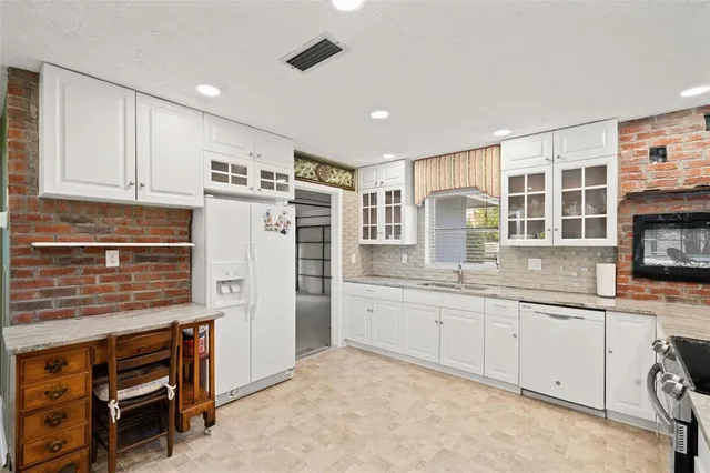 a kitchen with stainless steel appliances granite countertop a refrigerator and a stove top oven