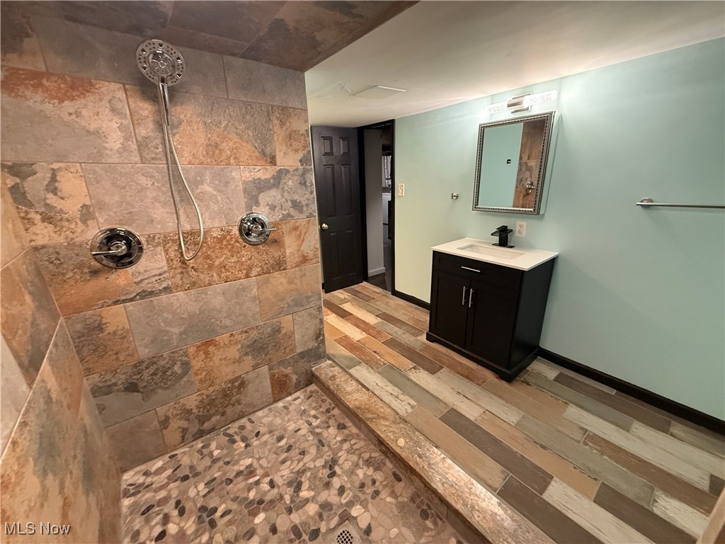 4658 Burleigh Road Cleveland, OH 44125 - Photo 19 of 24 Full bathroom with tiled shower, vanity, and light wood-style flooring