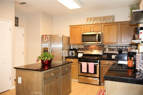 a kitchen with stainless steel appliances granite countertop a stove refrigerator and microwave