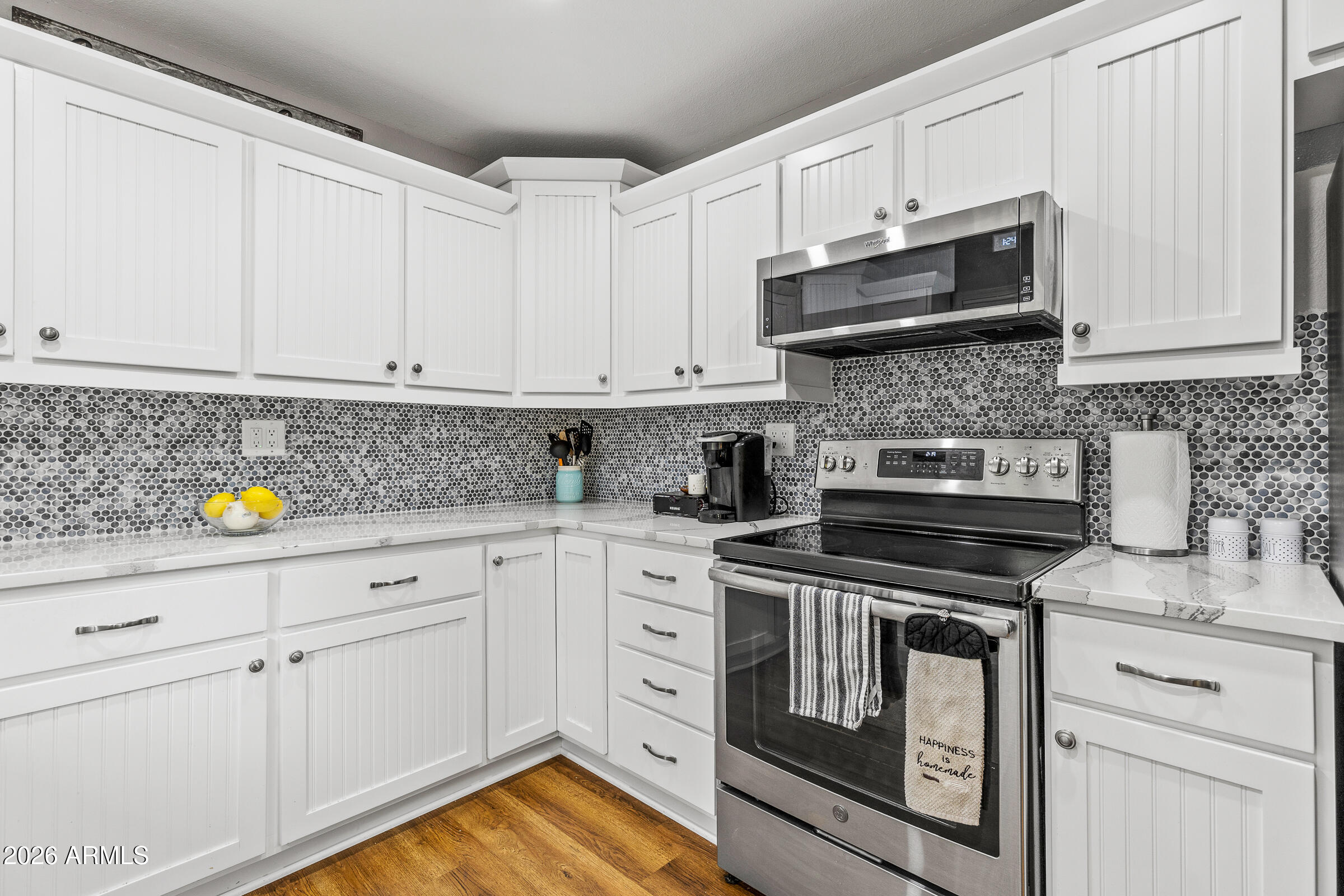 755 East Meadow View Road Munds Park, AZ 86017 - Photo 16 of 35 a kitchen with granite countertop white cabinets stainless steel appliances and a counter space
